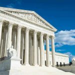 Supreme Court SMACKS DOWN 600 Schools Building with columns under a blue sky.