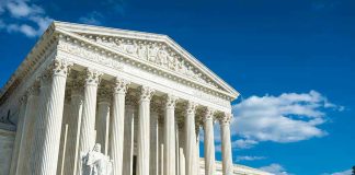 Supreme Court SMACKS DOWN 600 Schools Building with columns under a blue sky.