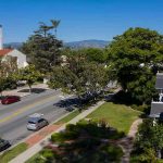 Justice TWIST Shuts Church Case Street with church, parked cars, and trees.