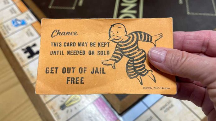1912210741 Hand holding Monopoly get out of jail card