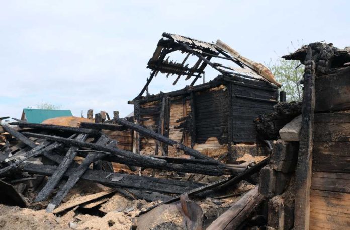 burned-wooden-village_1985943908 Burned wooden house with collapsed, charred beams and roof remains