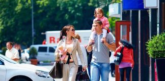 FAMILY OUTING Becomes War Zone — Many SHOT! A family walking on a sidewalk in an urban area, with a child on the fathers shoulders
