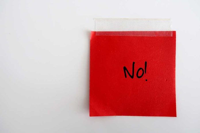 shutterstock_1536091325-1- A red sticky note with the word 'No!' written in black ink
