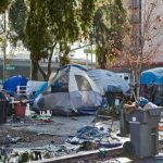Bill With a TWIST — An ACTUAL Homeless SOLUTION Homeless encampment with tents and trash in urban area.