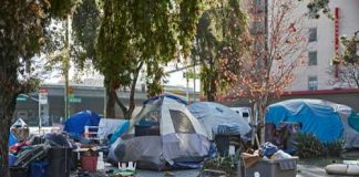 Bill With a TWIST — An ACTUAL Homeless SOLUTION Homeless encampment with tents and trash in urban area.