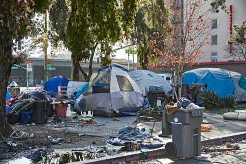 shutterstock_1542195449-2-1-1 Homeless encampment with tents and trash in urban area.