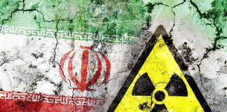 Trump’s ‘Great Deal’—Or Nuclear Mirage? A cracked wall featuring the Iranian flag and a nuclear warning symbol