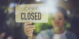 BELOVED Park Shuts Down — ACCUSATIONS are FLYING Hand hanging a closed sign on a shop door