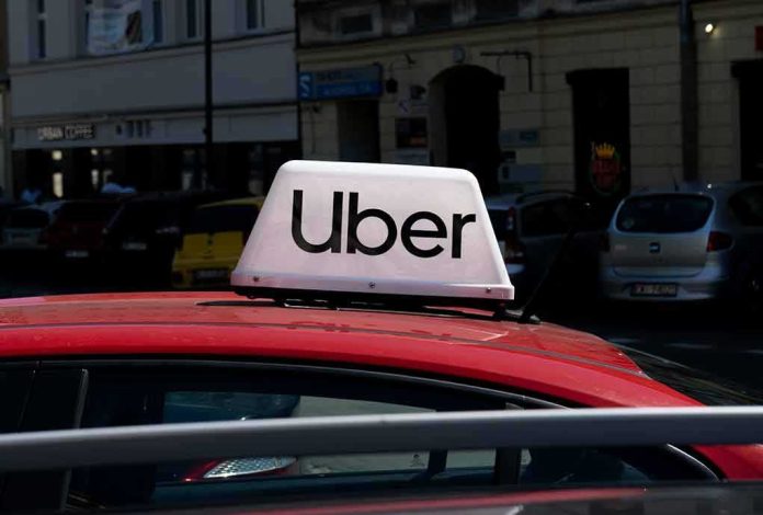 shutterstock_2352380579 Uber sign on top of a red car in an urban setting