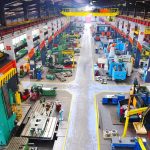 US Factory BOOM or Rigged Reality? Aerial view of a large industrial workshop filled with various machinery and equipment