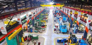 US Factory BOOM or Rigged Reality? Aerial view of a large industrial workshop filled with various machinery and equipment