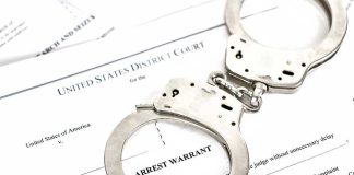 LATEST Chilling Trump Threat — VILE Online RANT Handcuffs on top of an arrest warrant document.