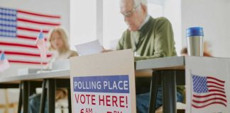 NONCITIZEN Voting BOMBSHELL Ignites The FEDS! Polling station with people voting, American flags visible.
