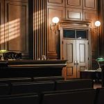 SURPRISE RULING — Judge FREEZES Michigan’s Power Grab Empty courtroom with judges bench and wooden decor.