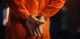 TOP SCANDAL — Democrat RISING STAR BUSTED — FELONY CHARGES! Person in orange jumpsuit with handcuffs behind back.