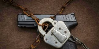 July 4TH GUN WAR Erupts Pistol locked with chains and a padlock.