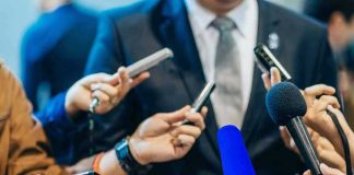 REVEALED — Therapist’s Emails IGNITE Political Firestorm Journalists holding microphones interview a person in a suit.