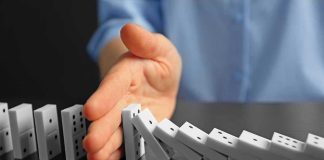 BLOCKBUSTER NEWS — Unanimous BAN Rocks ENTIRE COUNTRY Hand stopping falling row of dominoes.