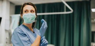 Prison Pedophile PROTECTED — Nurse GETS PUNISHED! Nurse wearing scrubs and mask putting on gloves.