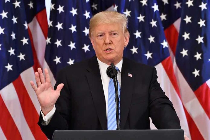 shutterstock_1198949239 man speaking at podium with American flags behind