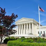 Supreme Court SPARKS New CULTURE WAR Supreme Court building with American flag and surrounding greenery