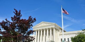 Supreme Court SPARKS New CULTURE WAR Supreme Court building with American flag and surrounding greenery