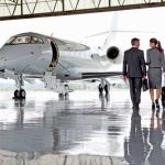 Oligarch Cash VANISHES — BILLIONS! Two businesspeople walking towards a private jet in hangar.