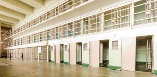 Elderly Bishop SNATCHED — No Warrant, No Why Interior view of a prison cell block with empty cells and security bars
