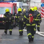 DEADLY House Inferno Hides Something MUCH MUCH Worse Firefighters walking toward a scene with hoses and a red emergency van
