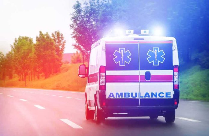 shutterstock_1011860305 Ambulance van with flashing lights on a rural road