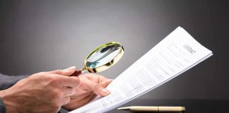 SCANDAL — Judges’ Opinions FLAGGED as AI-Written Hands holding magnifying glass over contract document