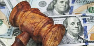 $410K Payout After PRONOUN Standoff Wooden judge's gavel on scattered US dollar bills
