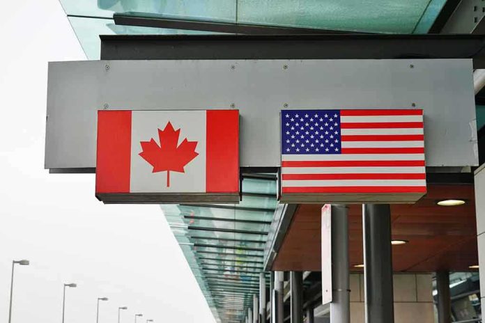 shutterstock_1044483421-2- Canadian and American flags displayed at a border crossing