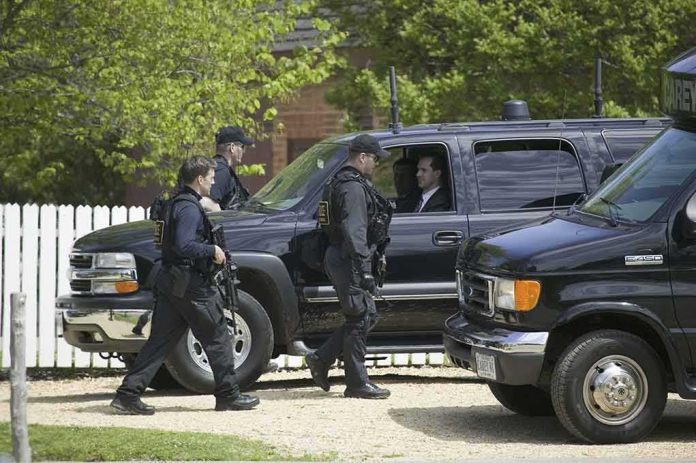 shutterstock_106042544 security officers walk past black SUVs during operation