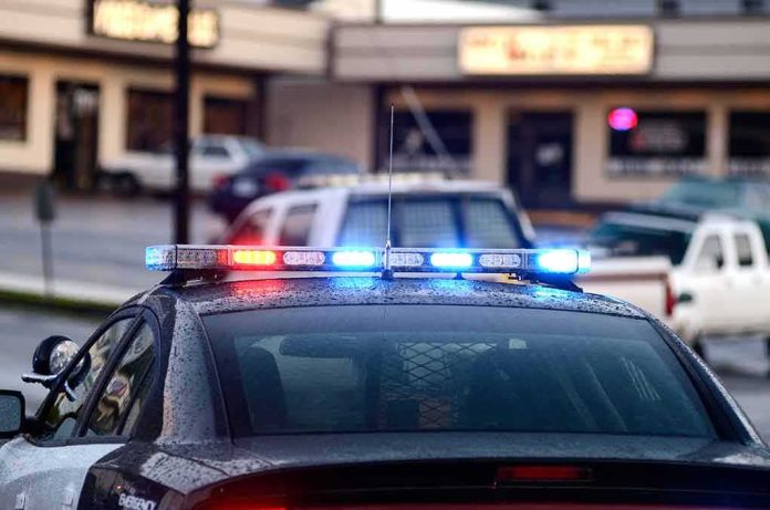 Police car with flashing red and blue lights in a parking lot