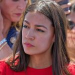 STUNNING — AOC REJECTED — LEFT Civil WAR Erupts woman in red top at an outdoor event