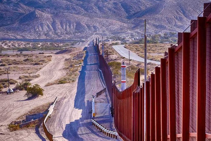 Border fence running through desert landscape