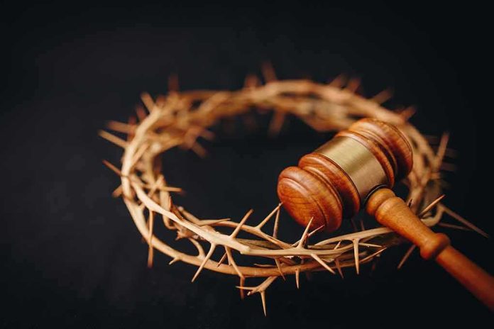 shutterstock_1677622840-1 Wooden judge's gavel beside a crown of thorns on a dark background