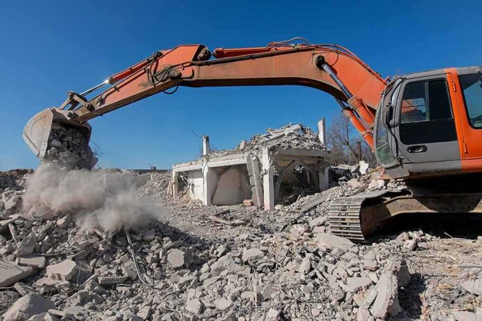 shutterstock_1684619659 Excavator demolishing a concrete building