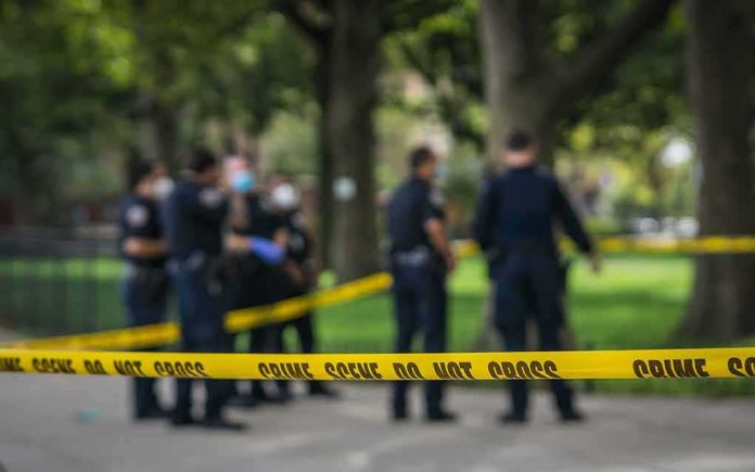 crime scene tape with police officers in a park