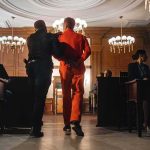 Lottery Sting TWIST — PROTECTOR Turns PREDATOR Prisoner in orange jumpsuit escorted by officer in a courtroom