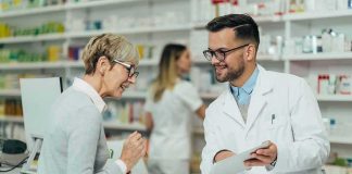 Drug Prices PLUNGE — What’s Behind It? Pharmacist assists customer at pharmacy counter