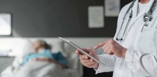 Grandma’s UNWANTED Death Sparks FAMILY Firestorm Doctor using tablet beside hospital patient