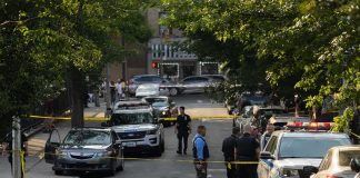 ROUTINE Stop Unmasks NIGHTMARE Passenger Police officers secure a residential street with patrol cars and yellow tape