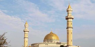 BRAWL Erupts — ISLAMIC EXPANSION Plan Still Passes Mosque with golden dome and two tall minarets under a partly cloudy sky