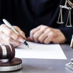Texas Law CRUMBLES — Drag WINS Judge writing at desk with gavel and Lady Justice statue