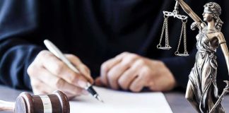 Texas Law CRUMBLES — Drag WINS Judge writing at desk with gavel and Lady Justice statue