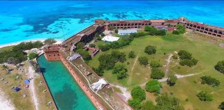 STUNNING NEWS — East Coast GOLDEN DOME Shield Debuts Aerial view of a coastal brick fort with moat and turquoise sea