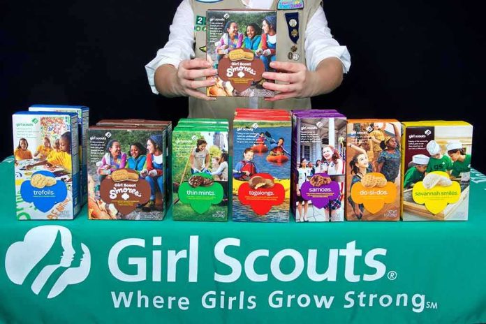 shutterstock_577870279 Girl Scout displays assorted cookie boxes on a table
