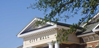 Mamdani JUST DUMPED 9/11 Files — What’s He Trying to HIDE? Exterior view of a city hall building with columns and a clear blue sky
